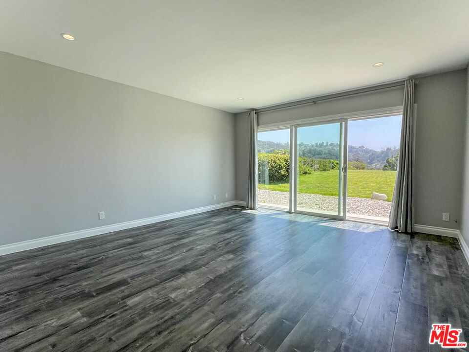 3824 Surfwood Road Malibu, CA 90265 - Photo 26 of 36 a view of an empty room with wooden floor and a window