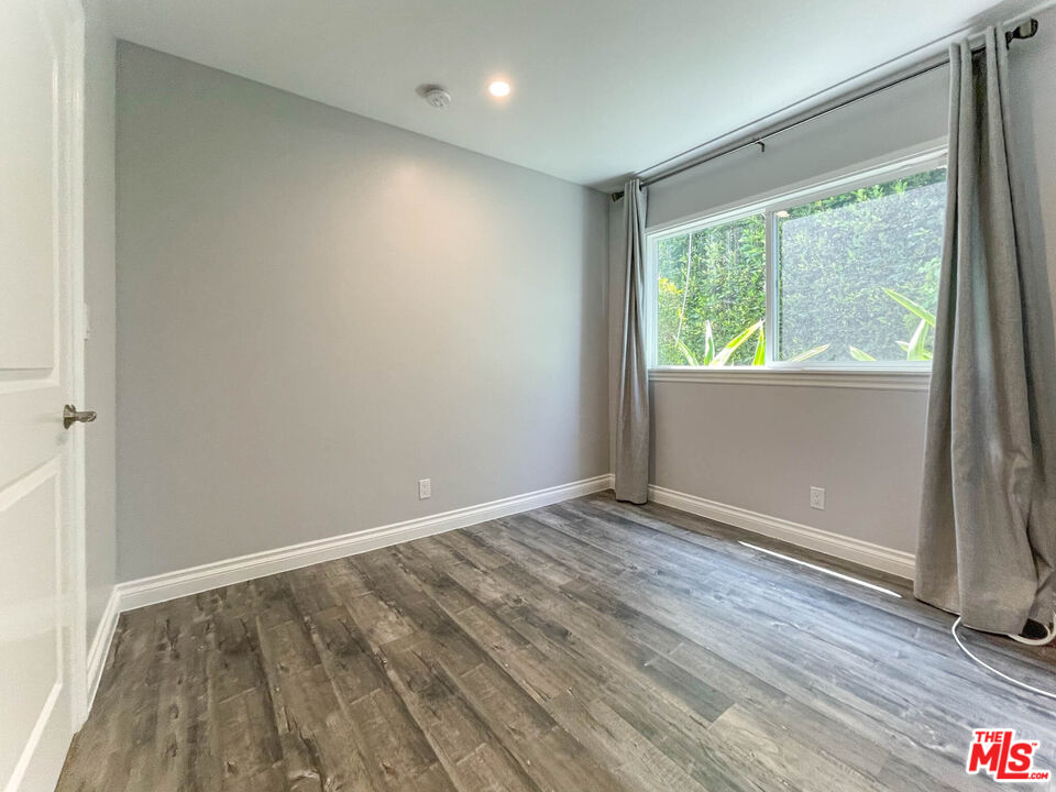 3824 Surfwood Road Malibu, CA 90265 - Photo 10 of 36 a view of an empty room with wooden floor and a window
