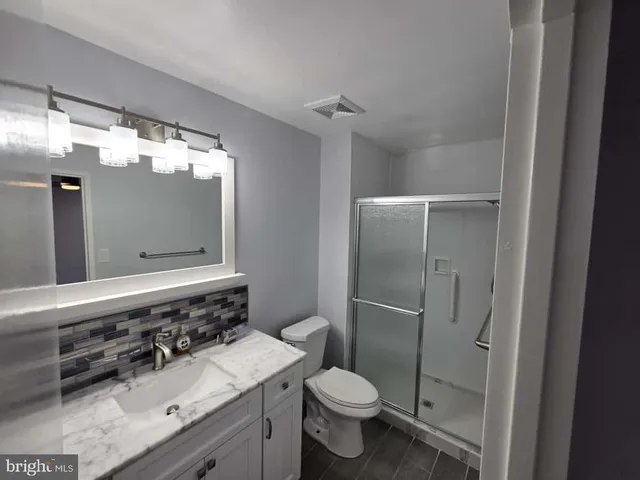 a bathroom with a sink vanity mirror and toilet
