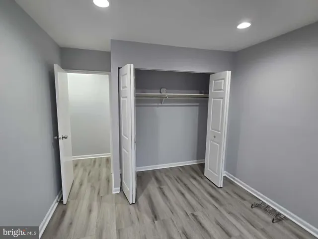 an empty room with wooden floor and entrance