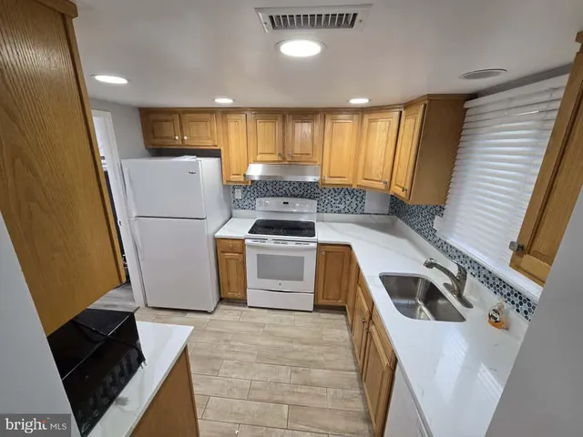 a kitchen with a refrigerator sink and stove