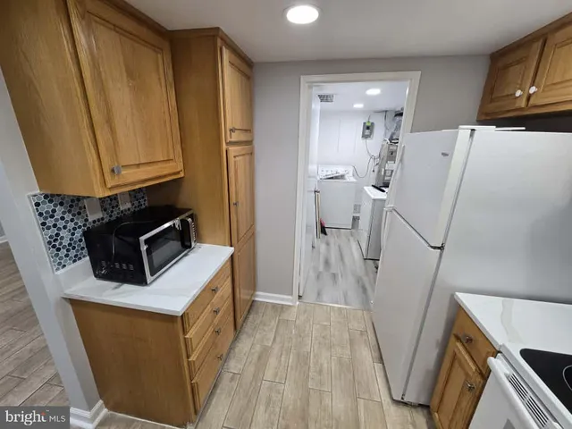 a kitchen with a refrigerator a sink and wooden floor