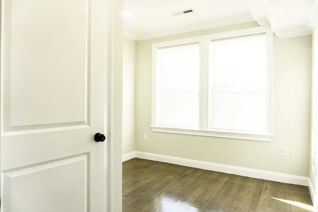 a view of a small space with wooden floor and a window