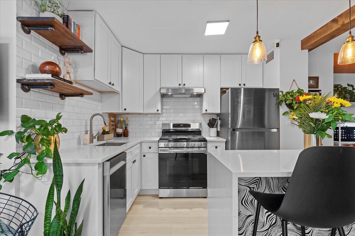 850 North Dewitt Place, Unit 7F Chicago, IL 60611 - Photo 4 of 13 a kitchen with stainless steel appliances a stove a refrigerator coffee table and chairs