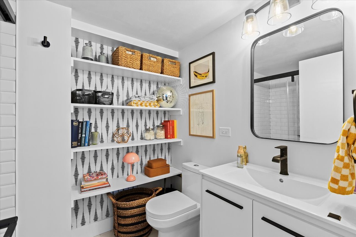 850 North Dewitt Place, Unit 7F Chicago, IL 60611 - Photo 10 of 13 a bathroom with a sink a toilet and a mirror