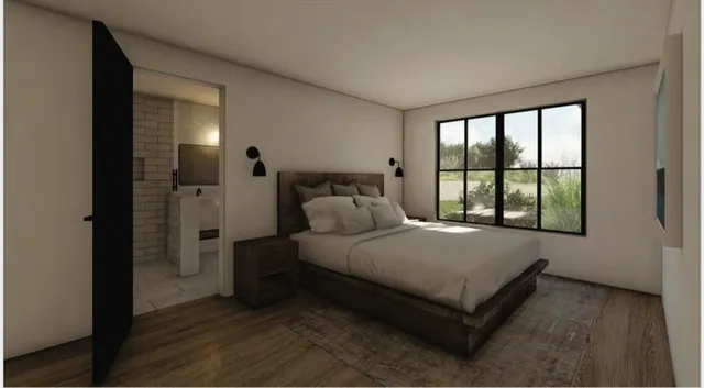 a bed sitting in a spacious bedroom next to a window