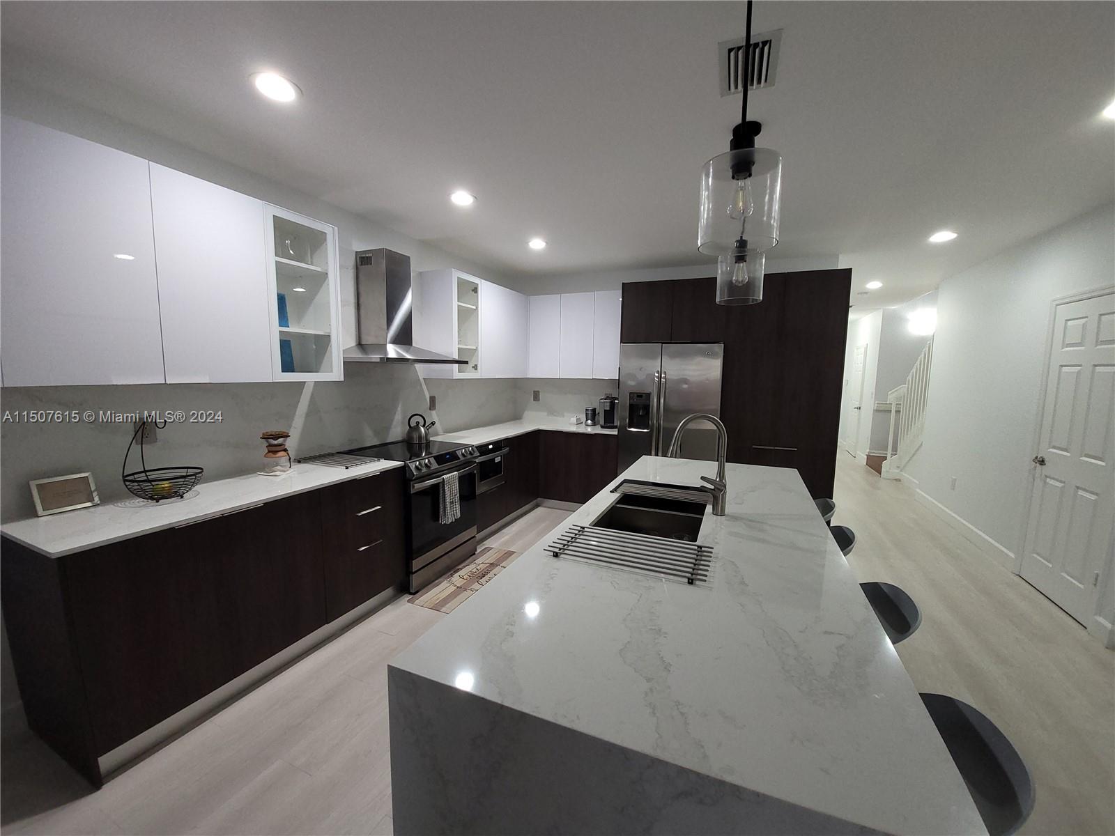 293 Las Brisas Circle Sunrise, FL 33326 - Photo 12 of 69 a kitchen with granite countertop a sink stainless steel appliances and cabinets