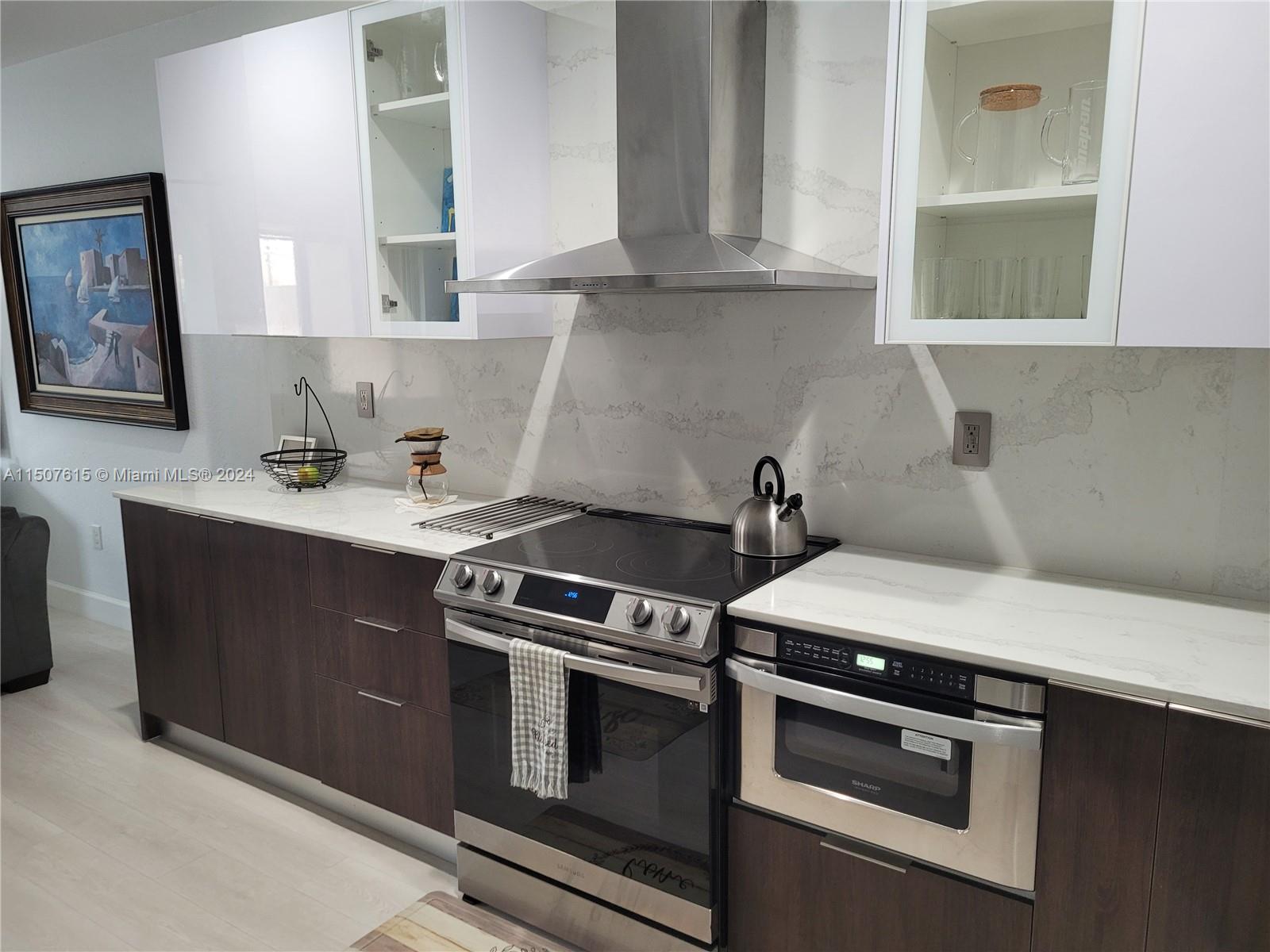 293 Las Brisas Circle Sunrise, FL 33326 - Photo 14 of 69 a kitchen with stainless steel appliances a stove a sink and white cabinets