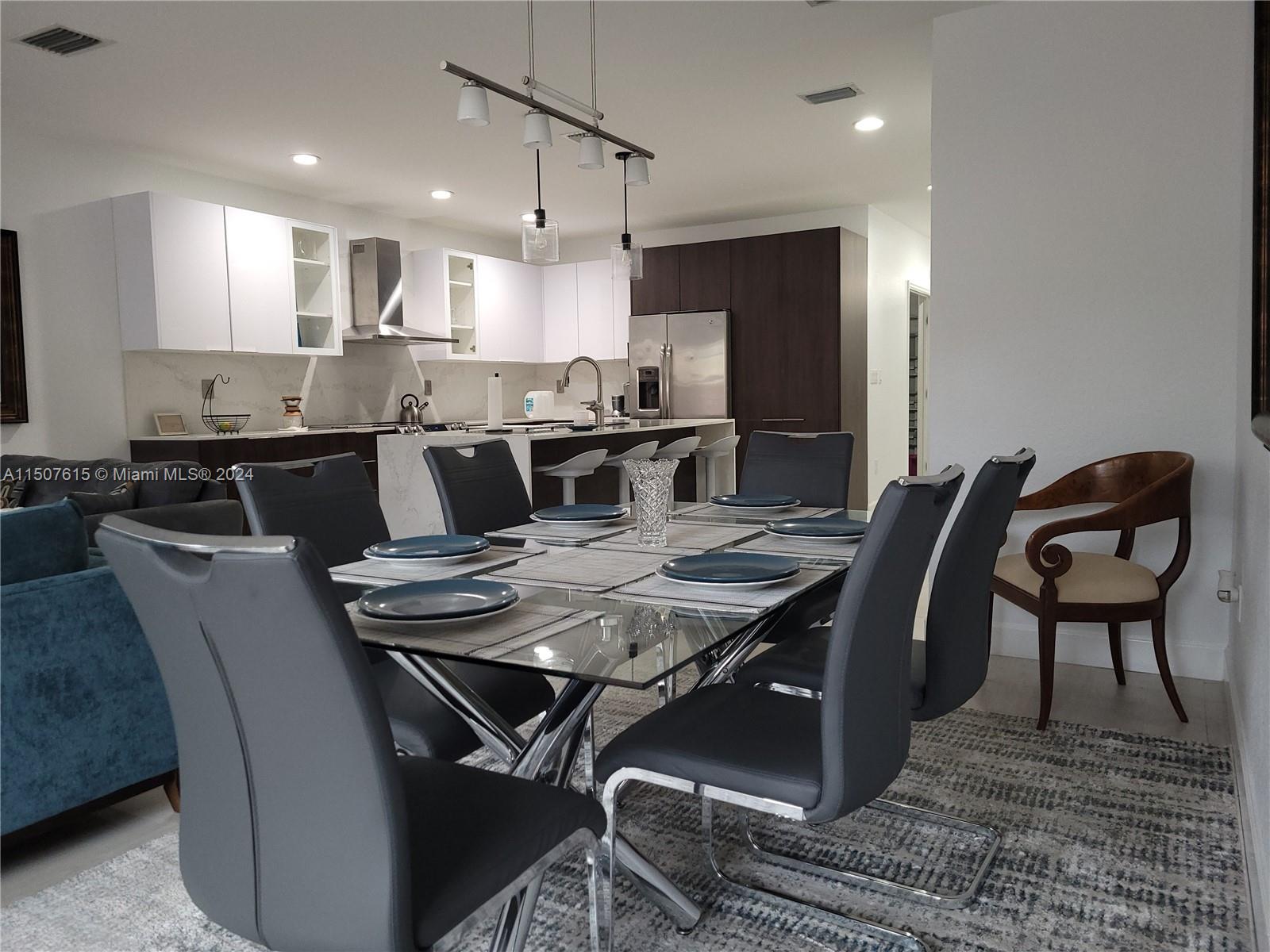 293 Las Brisas Circle Sunrise, FL 33326 - Photo 19 of 69 a kitchen with a dining table chairs and refrigerator