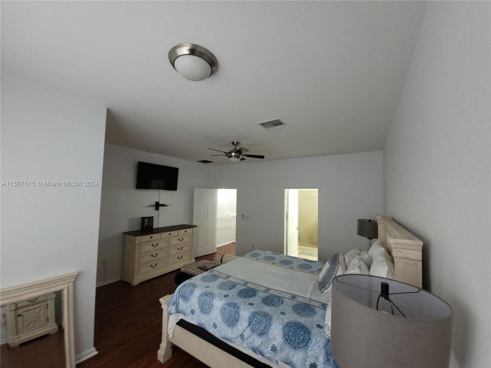 293 Las Brisas Circle Sunrise, FL 33326 - Photo 31 of 69 a spacious bedroom with a bed and a chandelier