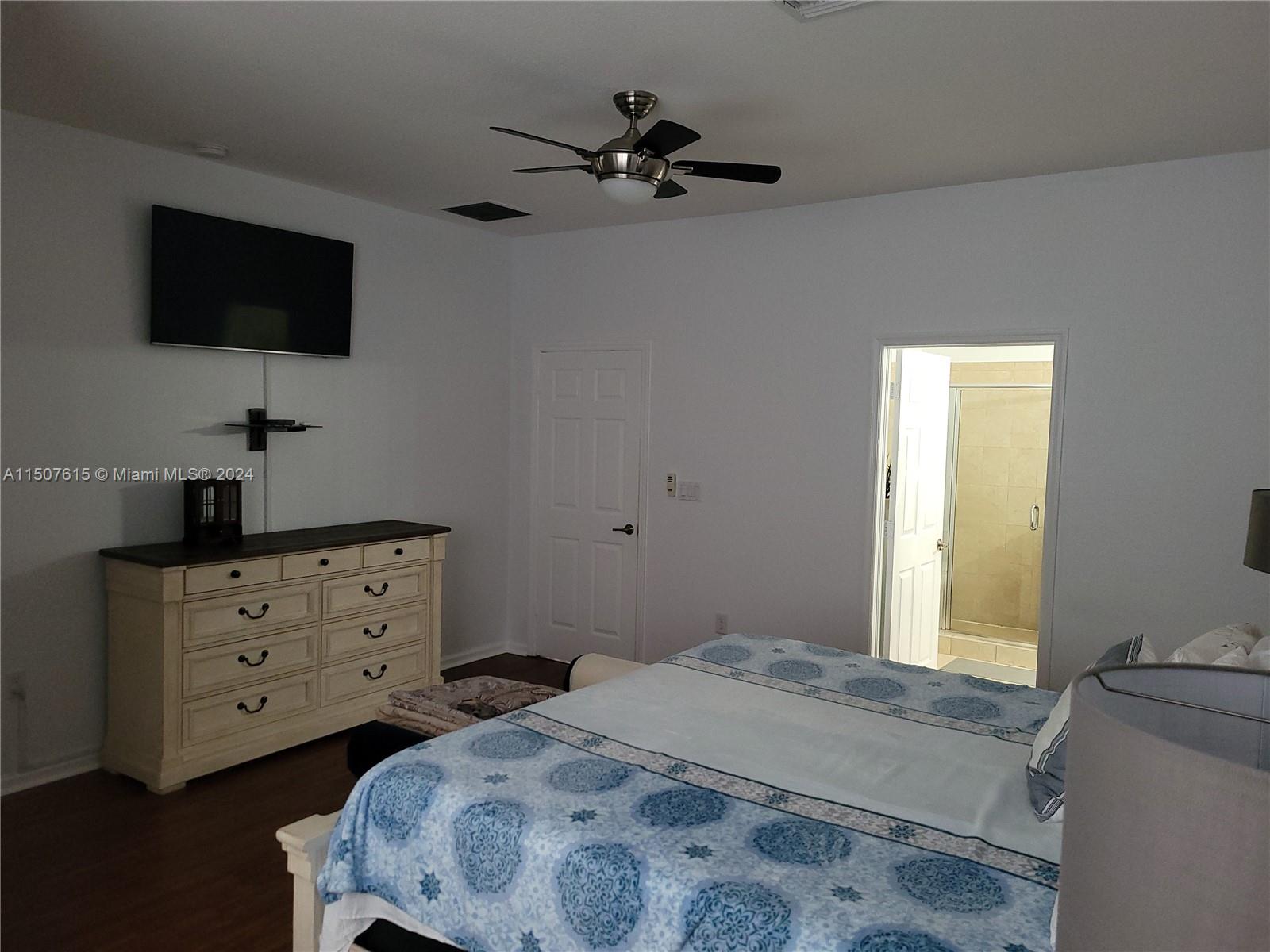 293 Las Brisas Circle Sunrise, FL 33326 - Photo 32 of 69 a bedroom with a bed and a flat tv screen on dresser