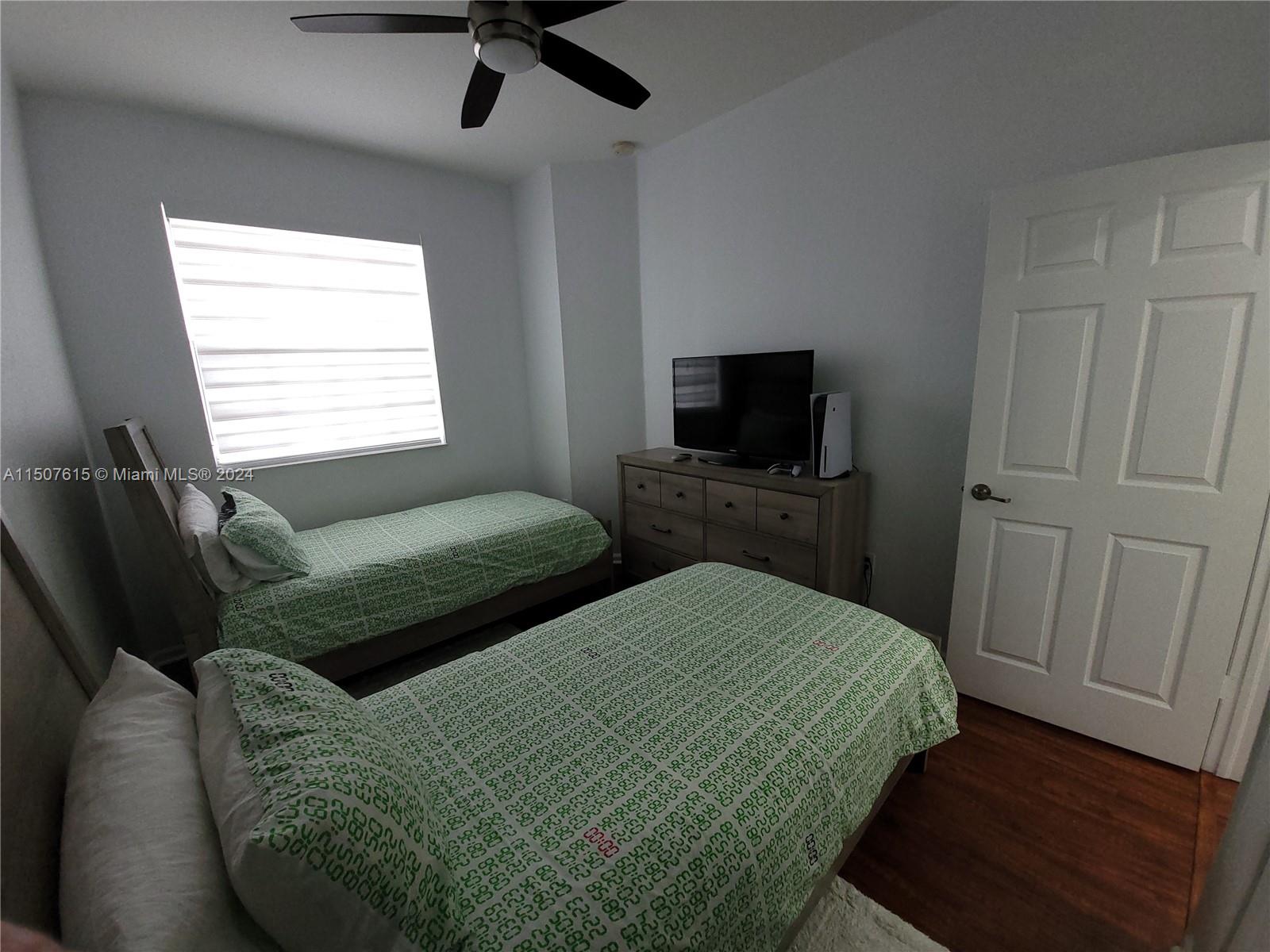 293 Las Brisas Circle Sunrise, FL 33326 - Photo 38 of 69 a bedroom with two beds and a flat screen tv