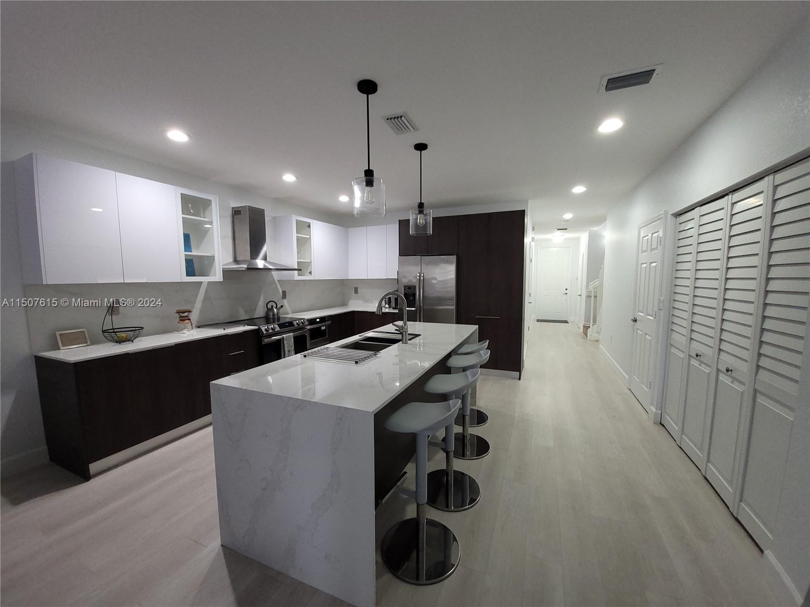 293 Las Brisas Circle Sunrise, FL 33326 - Photo 6 of 69 a kitchen with stainless steel appliances kitchen island a sink a stove a refrigerator and cabinets