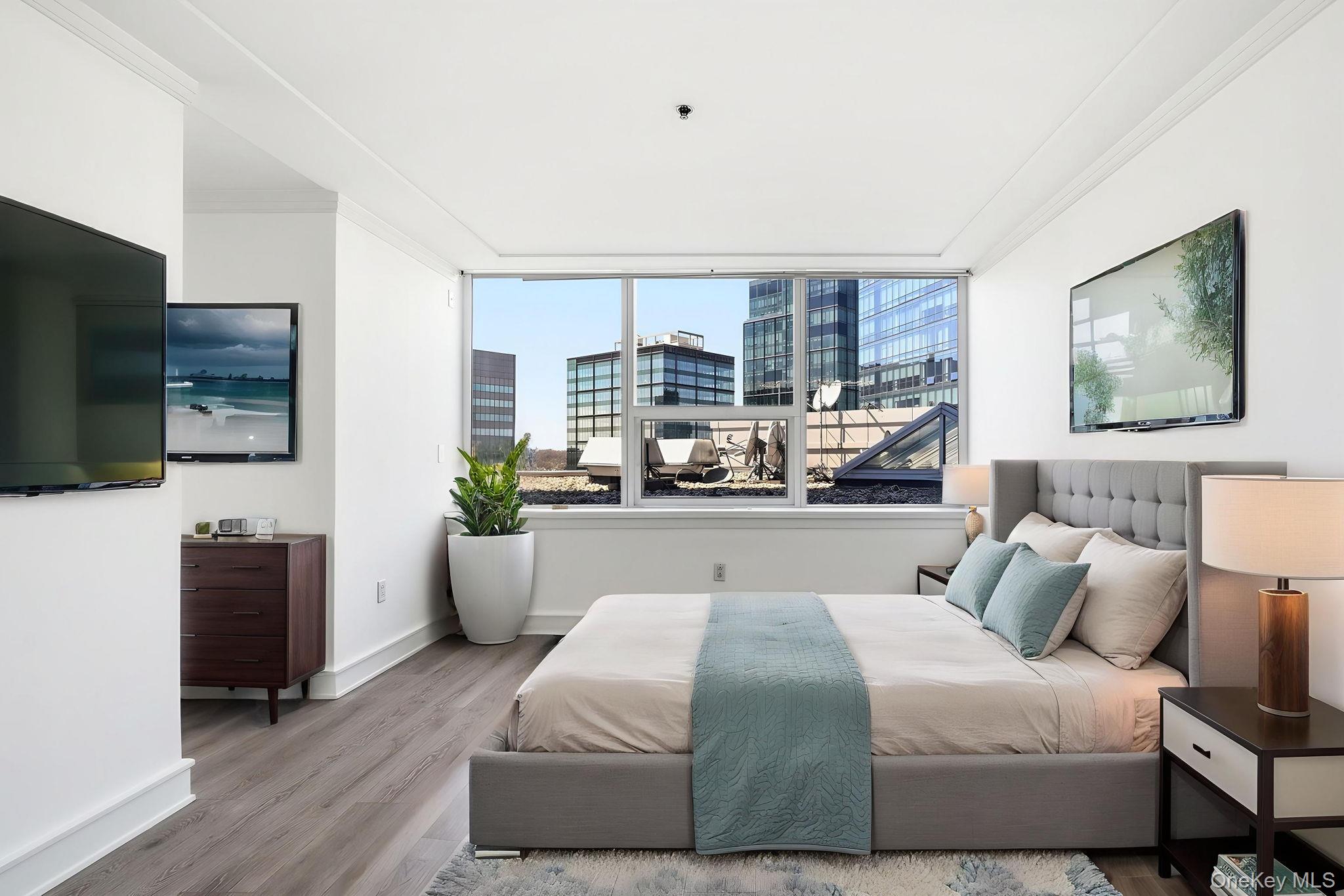 1 Renaissance Square, Unit 11G White Plains, NY 10601 - Photo 14 of 28 a bedroom with a large bed and a flat tv screen