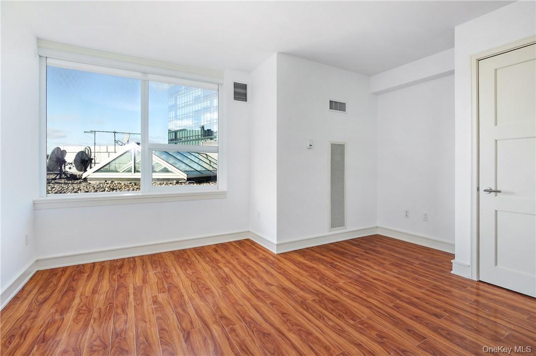 1 Renaissance Square, Unit 11G White Plains, NY 10601 - Photo 15 of 23 a view of a room with wooden floor and a ceiling fan
