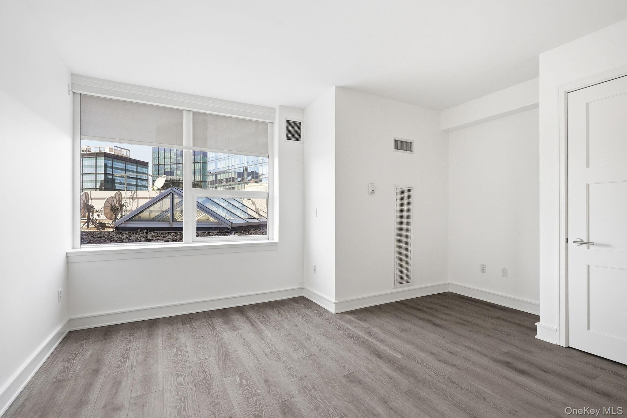 1 Renaissance Square, Unit 11G White Plains, NY 10601 - Photo 16 of 28 an empty room with wooden floor and windows