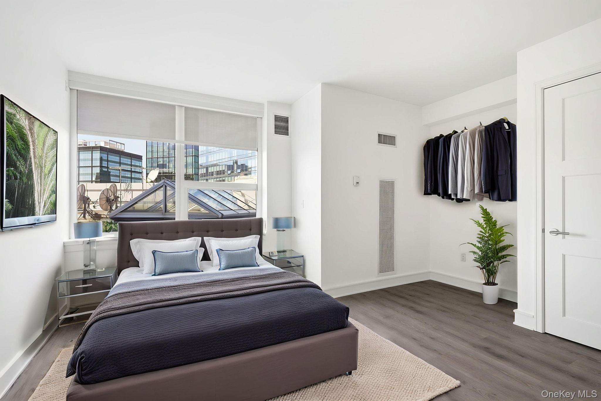 1 Renaissance Square, Unit 11G White Plains, NY 10601 - Photo 17 of 28 a bedroom with a bed and flat screen tv