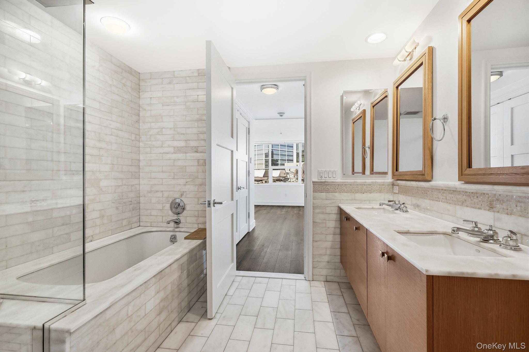 1 Renaissance Square, Unit 11G White Plains, NY 10601 - Photo 20 of 28 a bathroom with a tub sink and mirror