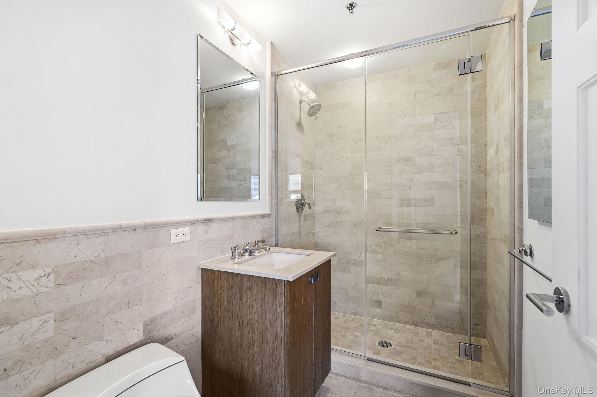 1 Renaissance Square, Unit 11G White Plains, NY 10601 - Photo 24 of 28 a bathroom with a shower a mirror and a sink