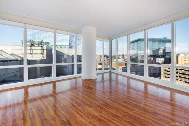 a view of a living room with wooden floor and windows