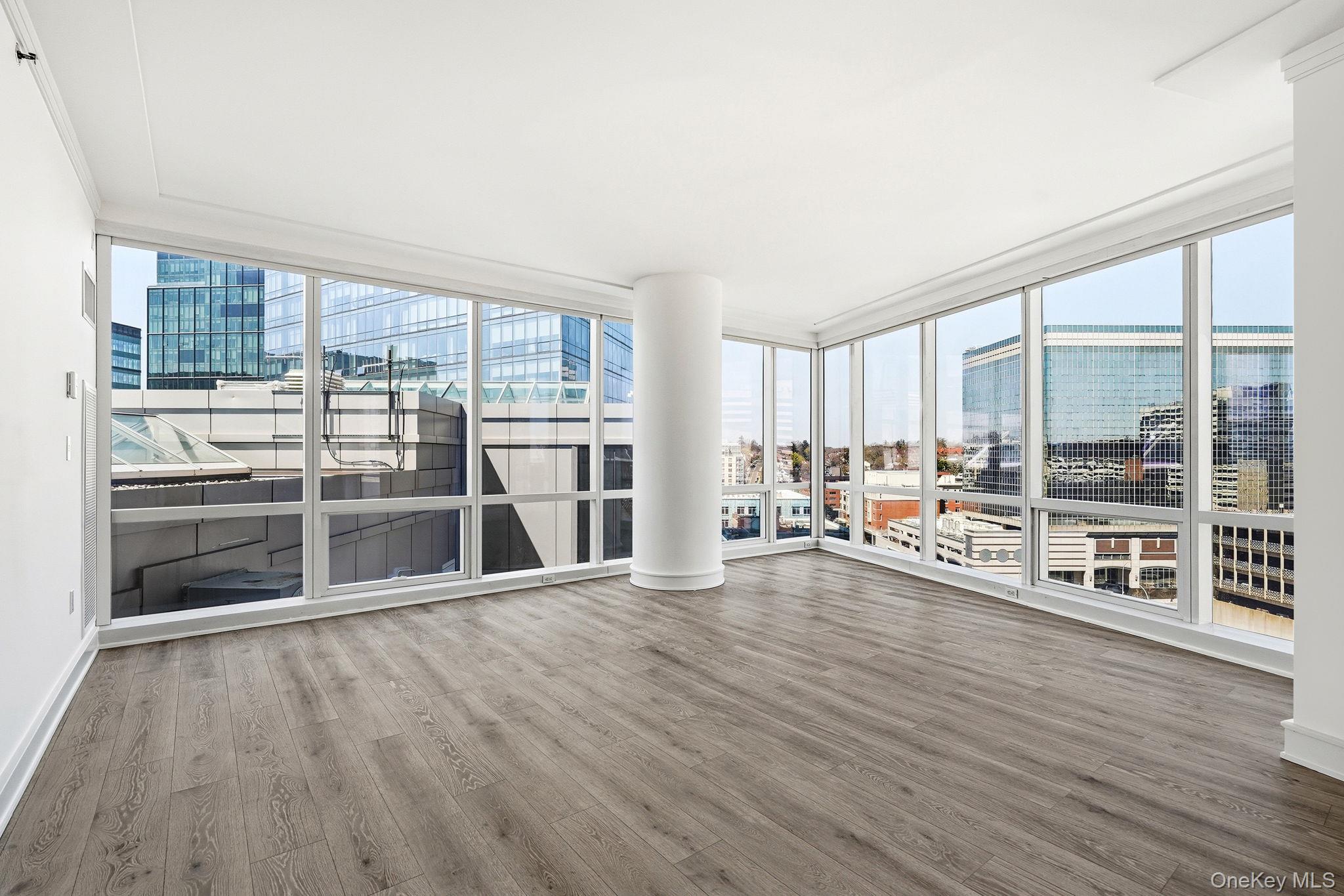 1 Renaissance Square, Unit 11G White Plains, NY 10601 - Photo 4 of 28 a room with lots of wooden furniture and a large window