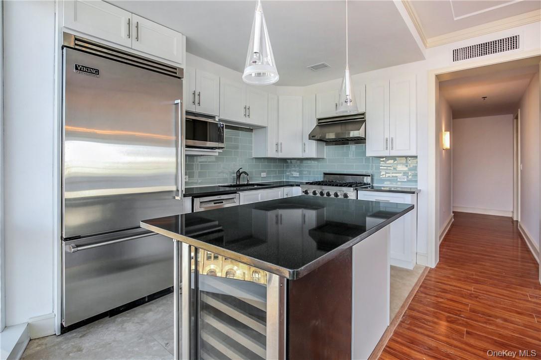 1 Renaissance Square, Unit 11G White Plains, NY 10601 - Photo 4 of 23 a kitchen with kitchen island granite countertop a sink stainless steel appliances and cabinets