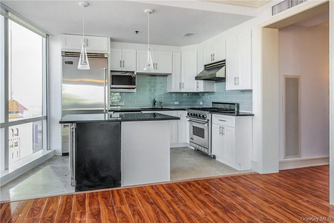 1 Renaissance Square, Unit 11G White Plains, NY 10601 - Photo 5 of 23 a kitchen with stainless steel appliances granite countertop a stove a sink and a refrigerator