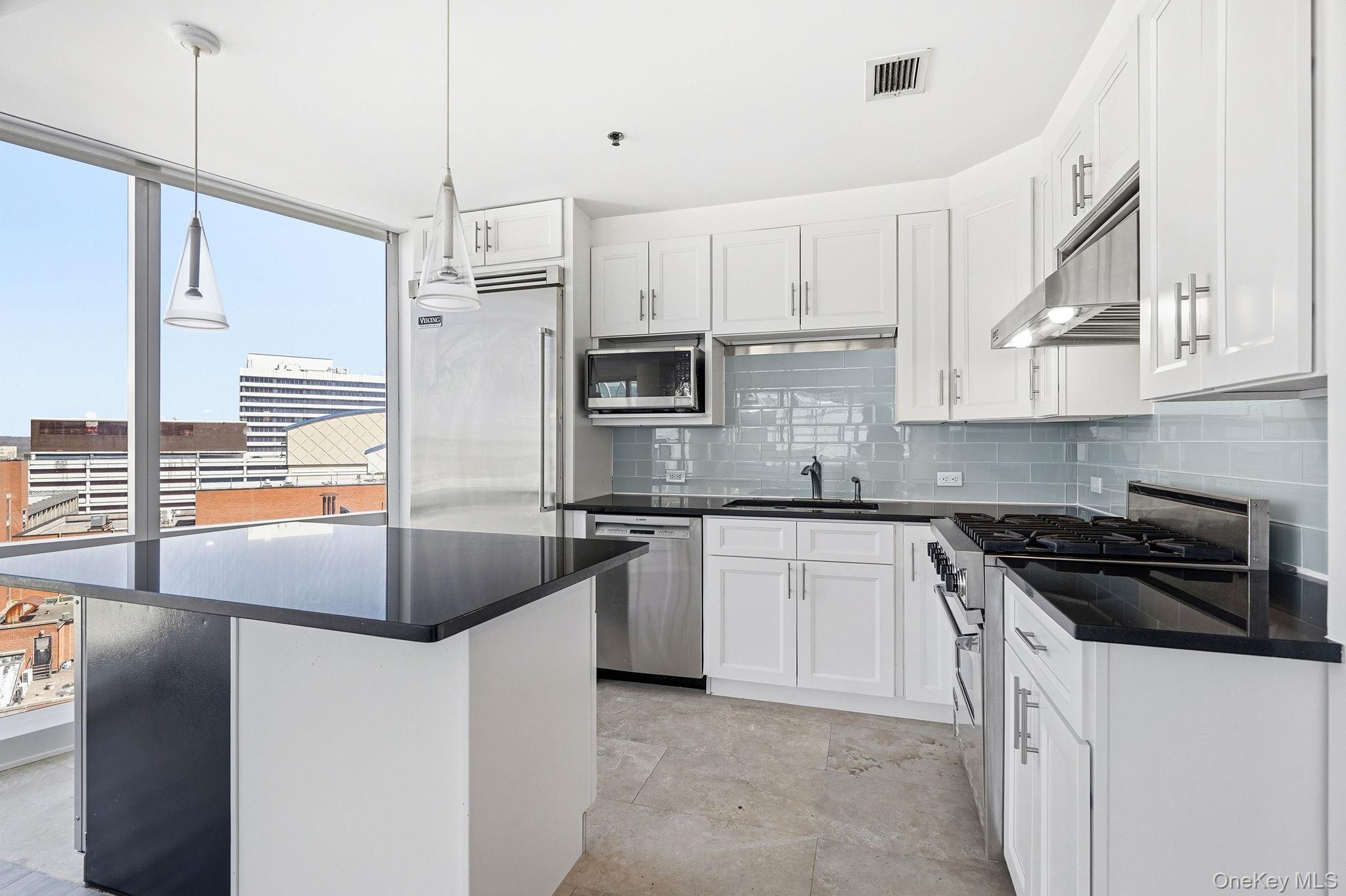 1 Renaissance Square, Unit 11G White Plains, NY 10601 - Photo 6 of 28 a kitchen with stainless steel appliances granite countertop a stove a sink and a refrigerator