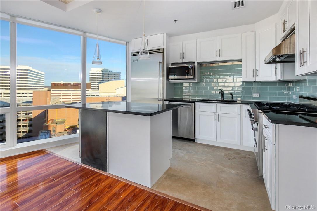 1 Renaissance Square, Unit 11G White Plains, NY 10601 - Photo 6 of 23 a kitchen with stainless steel appliances granite countertop a stove a sink and a refrigerator