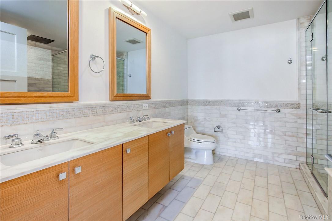 1 Renaissance Square, Unit 11G White Plains, NY 10601 - Photo 9 of 23 a bathroom with a double vanity sink toilet and shower