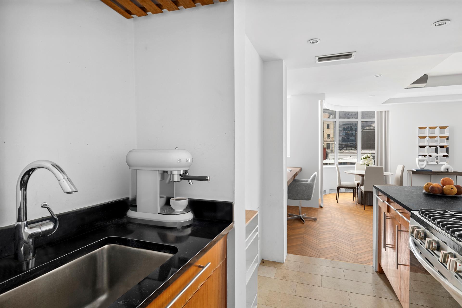 24 West 55th Street, Unit 11D Manhattan, NY 10019 - Photo 4 of 18 a kitchen with a sink and a stove top oven