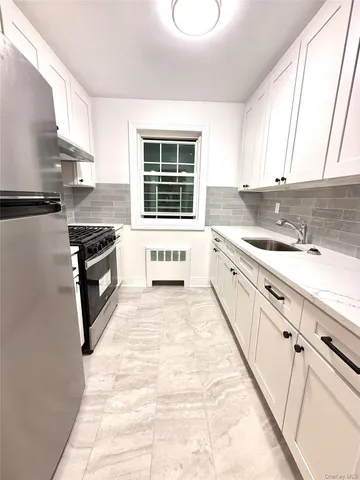 a kitchen with granite countertop a stove sink and cabinets