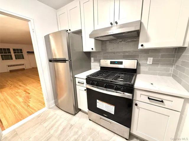 a kitchen with a stove top oven and refrigerator