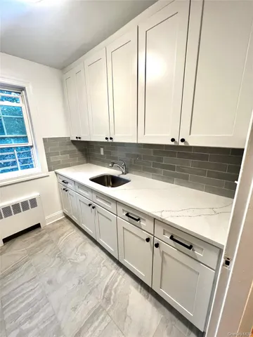 a kitchen with granite countertop white cabinets and sink