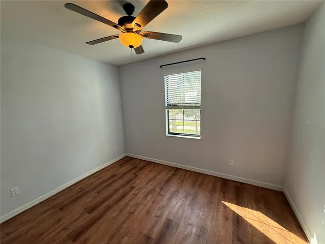 an empty room with windows and fan