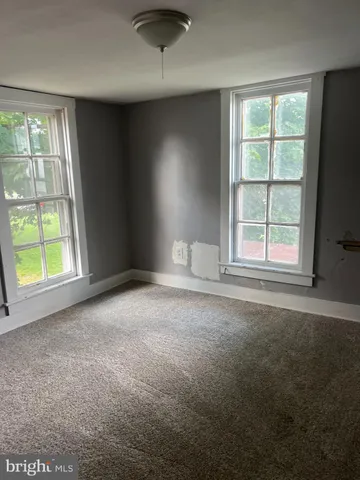 an empty room with windows and closet