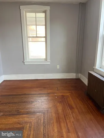 a view of a room with wooden floor and a window