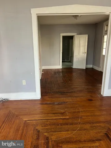 a view of empty room with window and wooden floor