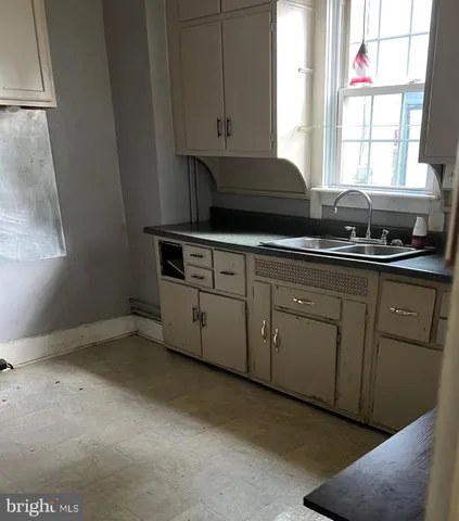a kitchen with granite countertop white cabinets and a sink