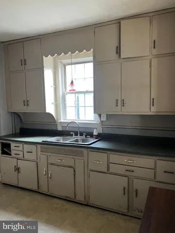 a kitchen with stainless steel appliances granite countertop white cabinets sink and window