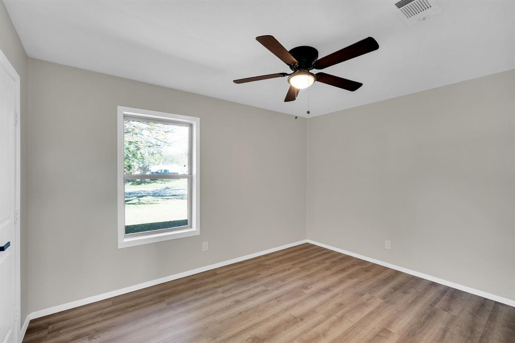 221 North Edgefield Road Waxahachie, TX 75165 - Photo 17 of 27 a view of a big room with wooden floor closet and windows in it
