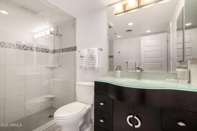 a bathroom with a sink toilet double vanity and shower