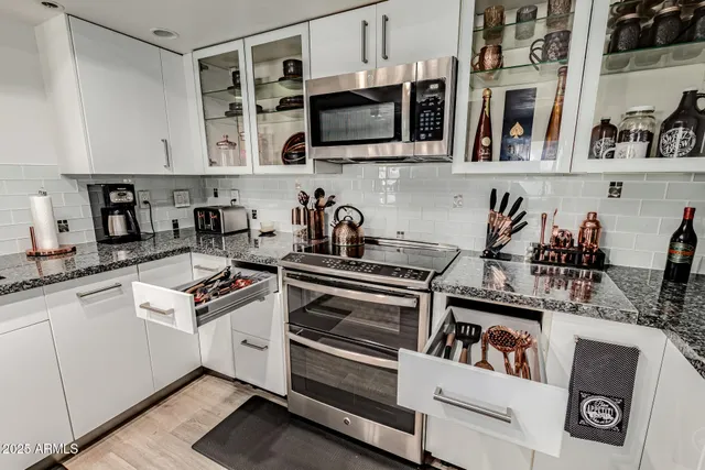 a kitchen with stainless steel appliances granite countertop a stove and cabinets