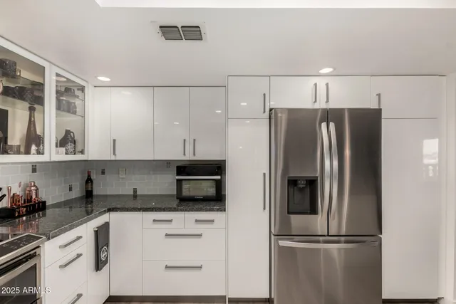 a kitchen with stainless steel appliances granite countertop a refrigerator and a stove