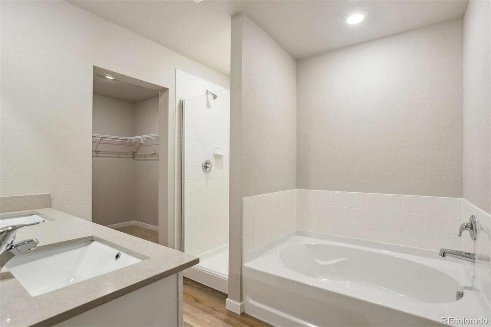 48165 Shetland Drive Bennett, CO 80102 - Photo 14 of 21 a bathroom with a bathtub and a sink