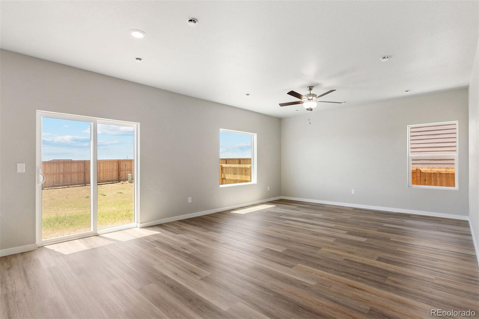 48165 Shetland Drive Bennett, CO 80102 - Photo 2 of 21 a view of an empty room with a window and wooden floor