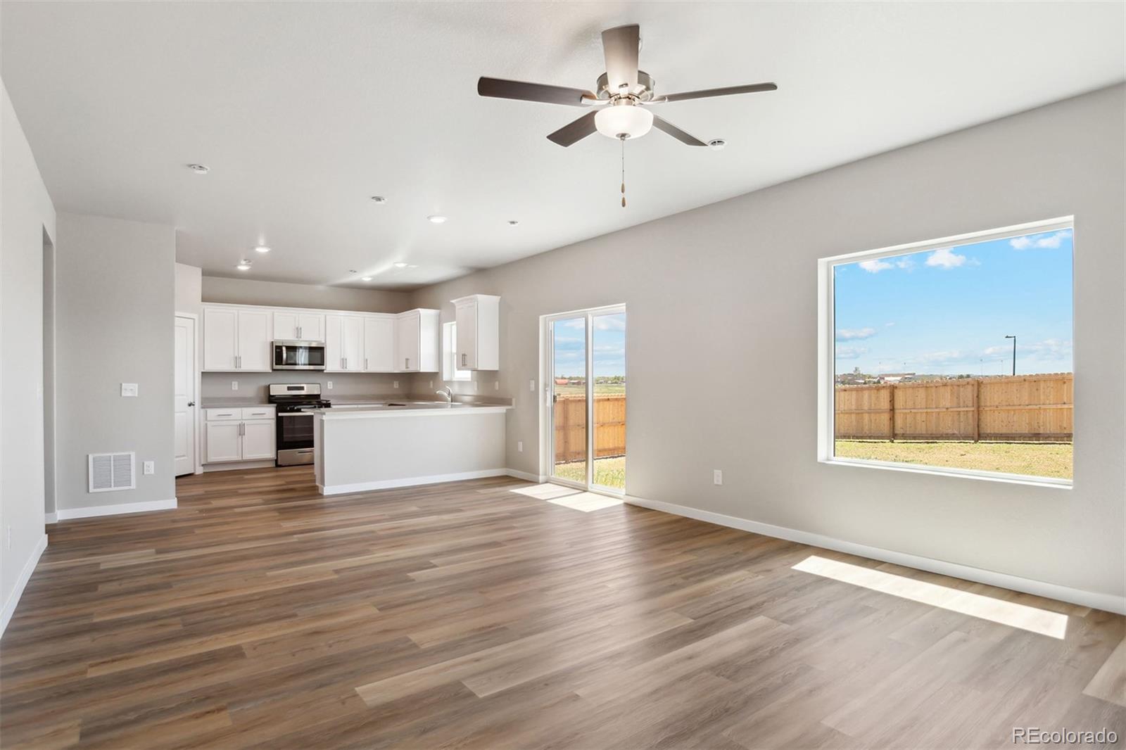 48165 Shetland Drive Bennett, CO 80102 - Photo 3 of 21 a view of a kitchen with a kitchen island wooden floor and a window