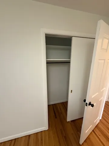 a view of walk in closet with wooden floor