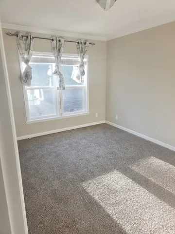 a view of empty room with wooden floor and door