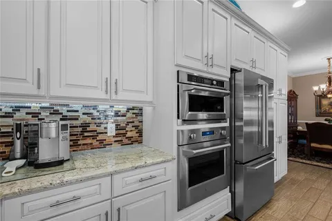 a kitchen with granite countertop a refrigerator oven and stainless steel appliances